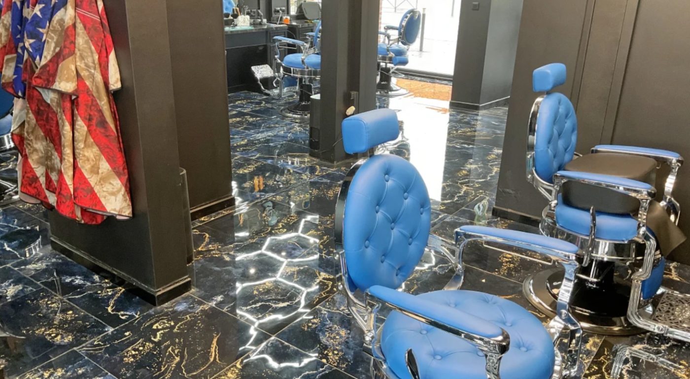 Fauteuils de barbier bleus et sol en marbre du salon Barber Factory