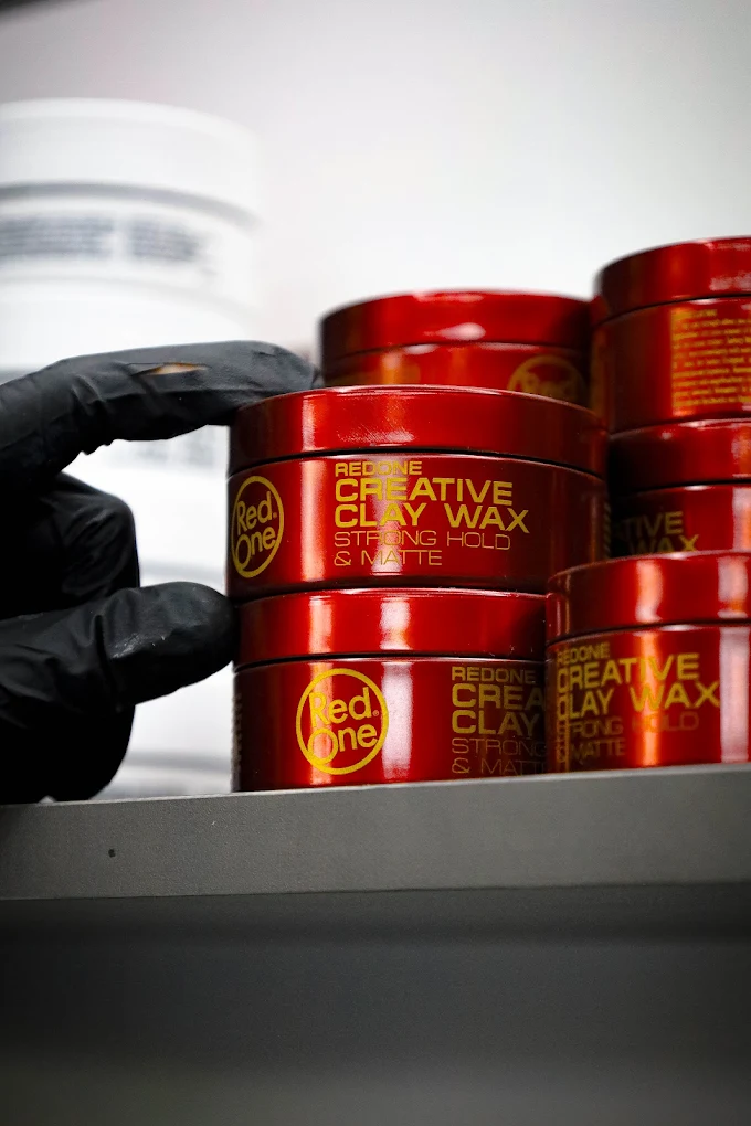 Pots de cire coiffante professionnelle rangés au salon